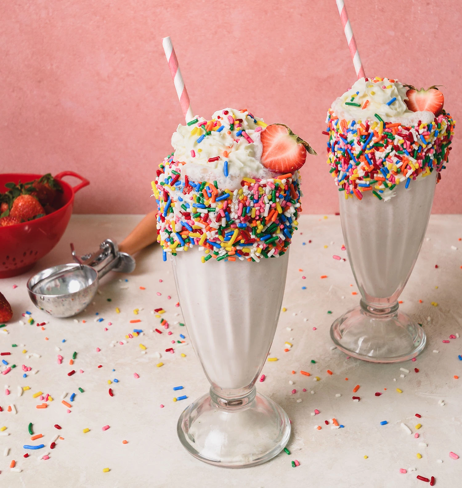 Homemade strawberry milkshake with strawberries and sprinkles.