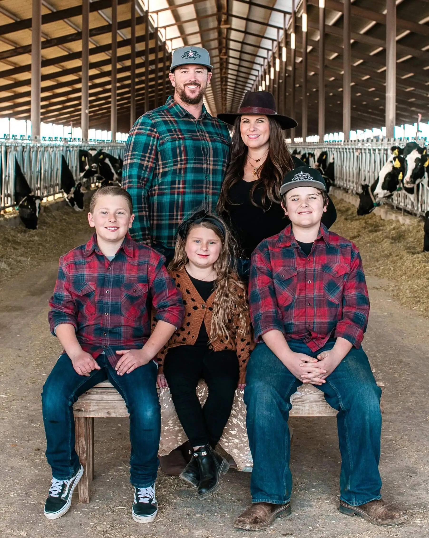 The Moroney family of Del Rio Dairy posing for a photo below their sustainable barn roof.