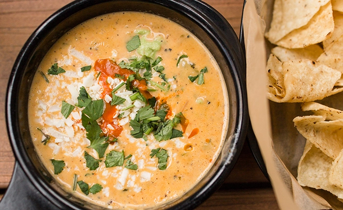 Mexican cheese dip casserole accompanied by a plate of chips.