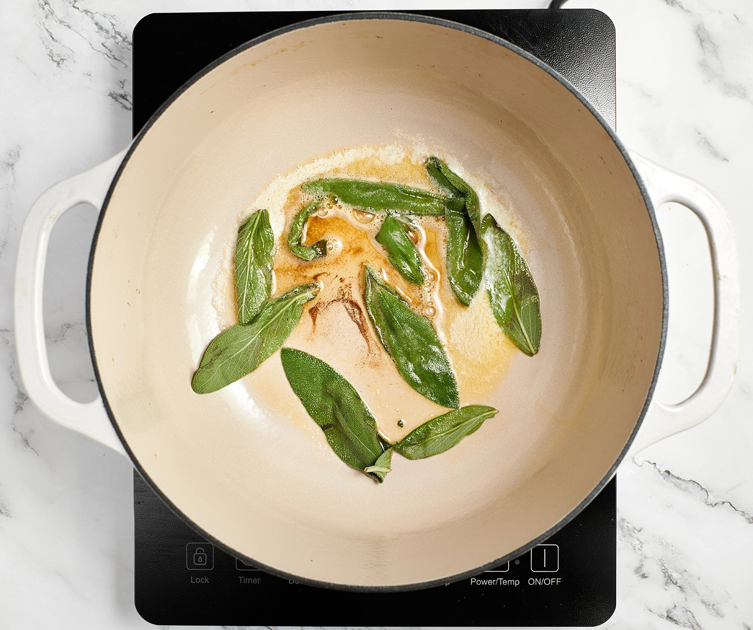 Sage leaves in a large pot with butter, cooked until fragrant and crisp.