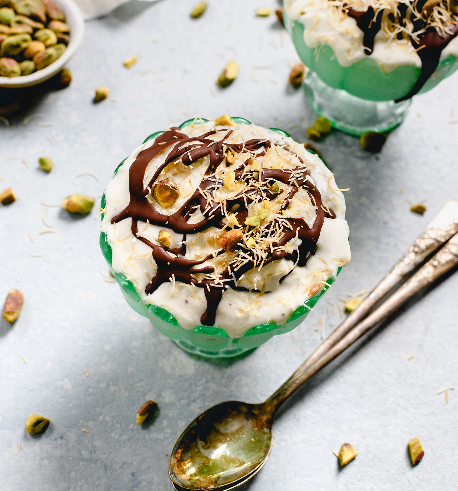 pistachio frozen yogurt with knafeh topped with pistachio cream and melted chocolate.