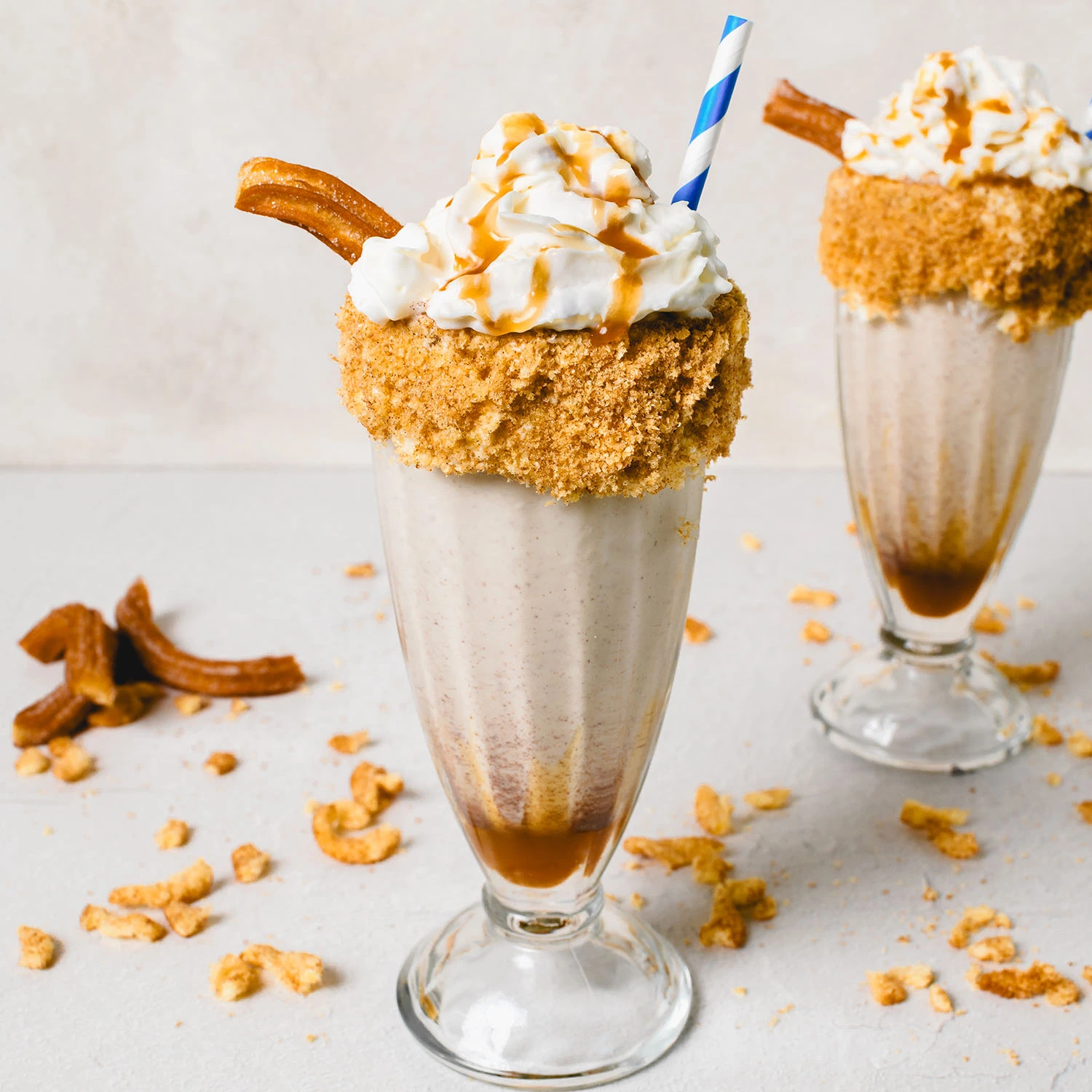 Spiked Caramel Churro Milkshake topped with crushed cinnamon sugar twists and whipped cream.