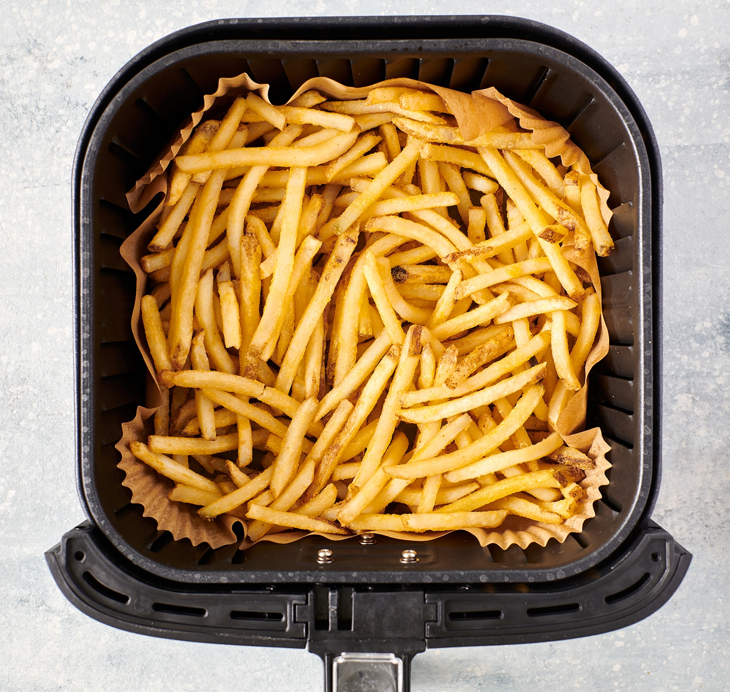 French fries cooked inside of an air fryer.