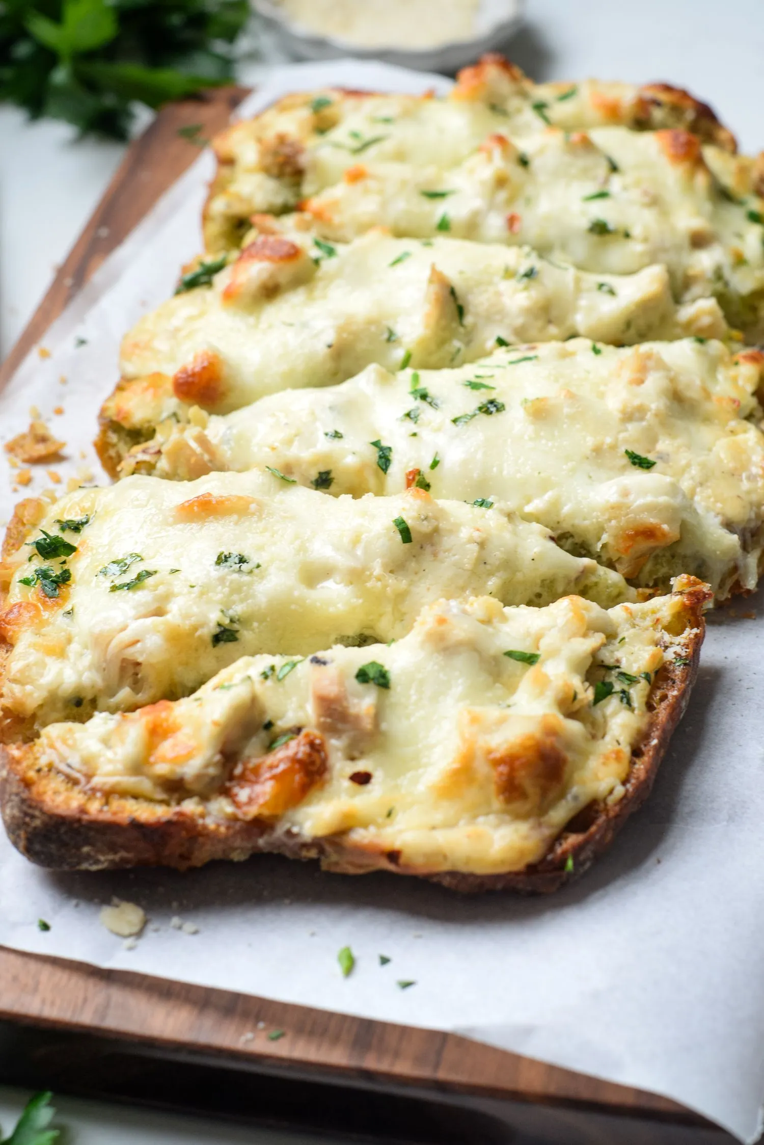 chicken-alfredo-garlic-final.jpg Six slices of baked alfredo garlic cheesy bread topped with parsley.