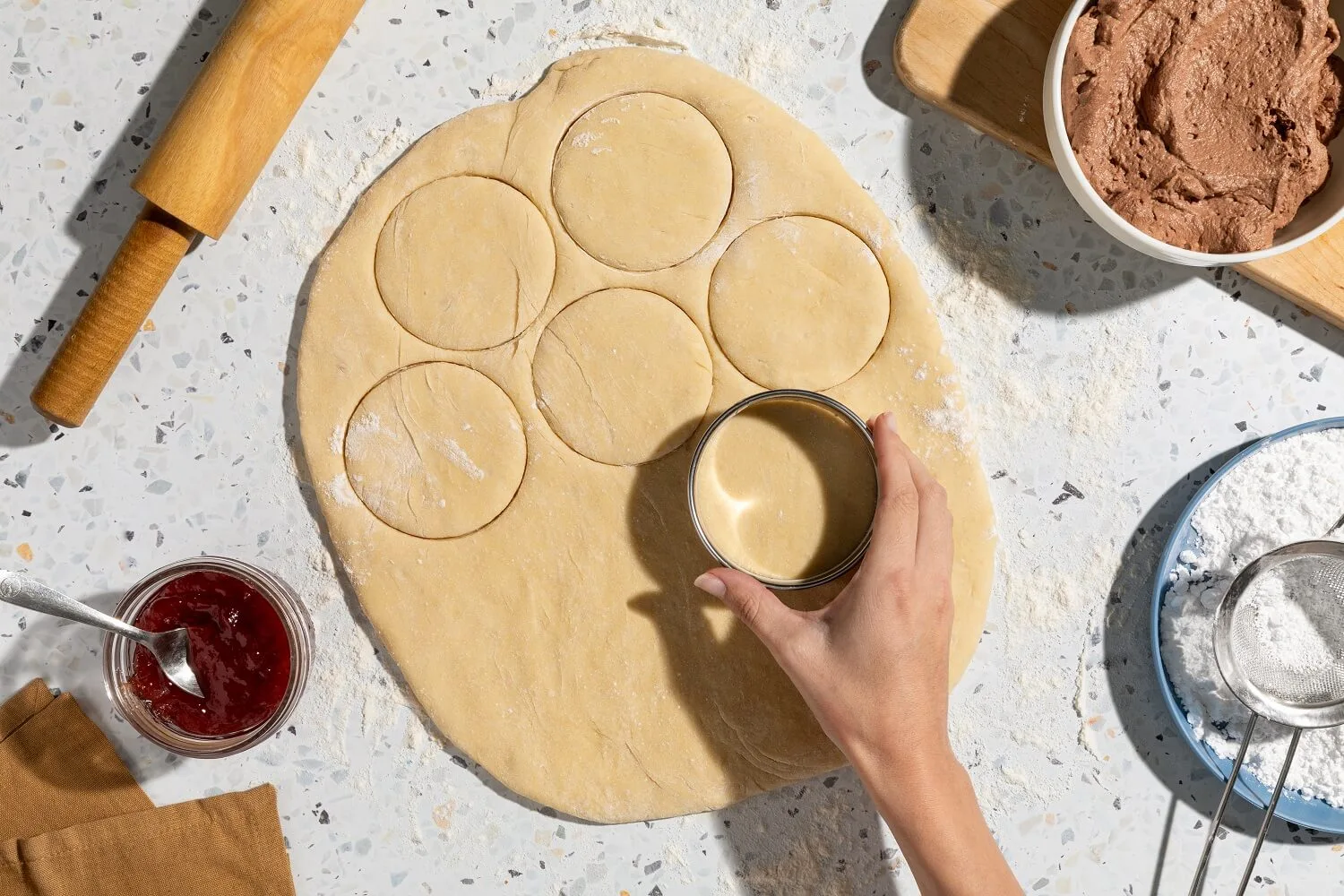 Sufganiyot dough being cut with a circular cutter.