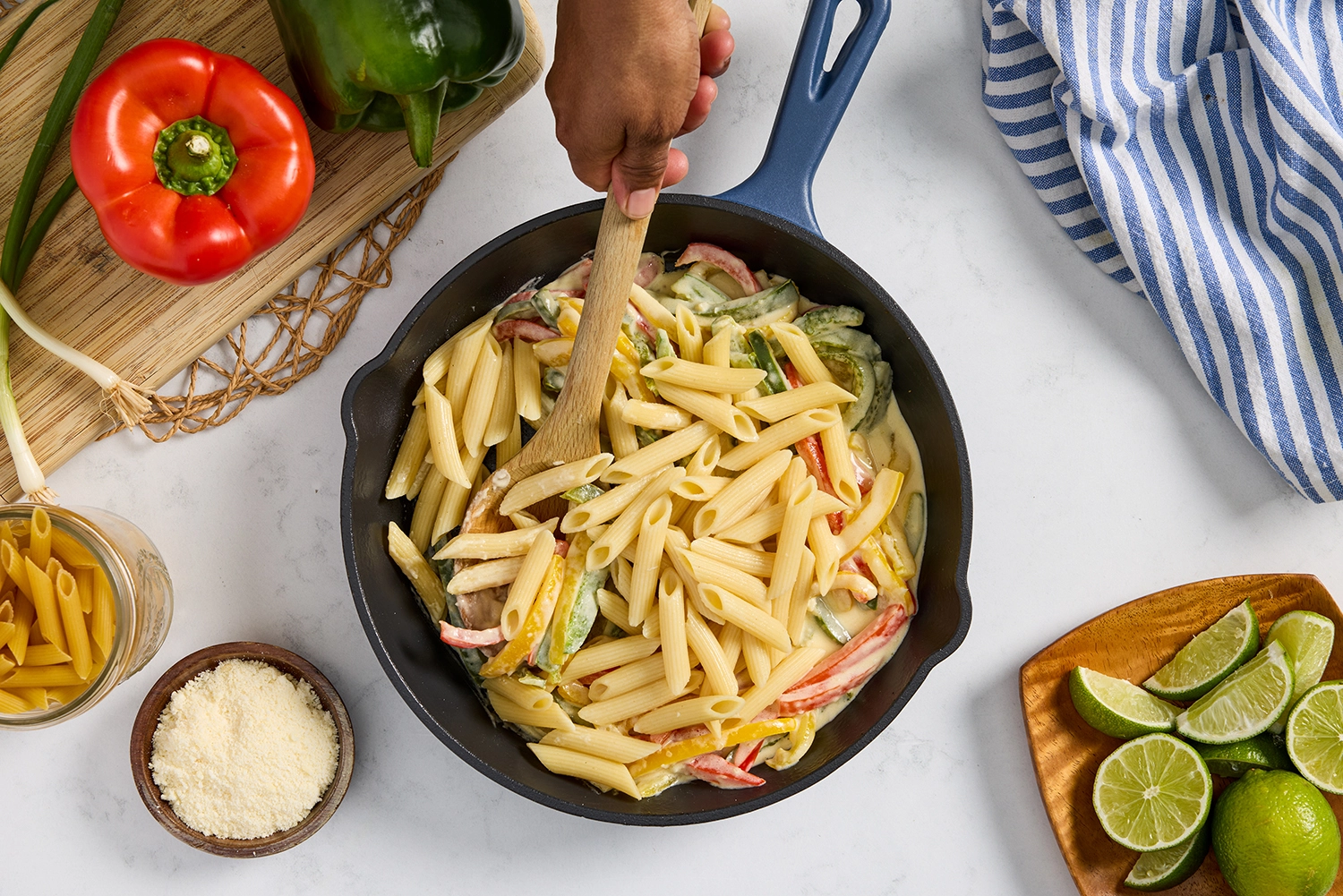 Rasta pasta with heavy cream and Parmesan, topped with green onions and lime wedges.