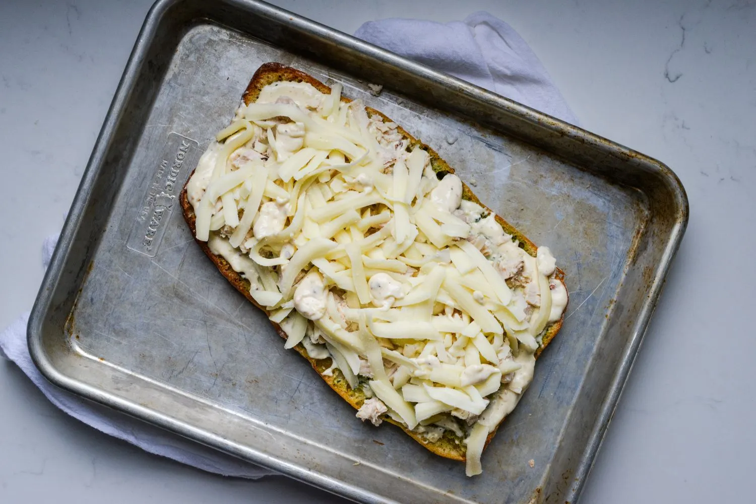 chicken-alfredo-garlic-5.jpg A softened mixture of garlic, butter, cream cheese, and Parmesan is spread over Ciabatta bread, topped with chicken and Mozzarella cheese, and placed on a baking pan.