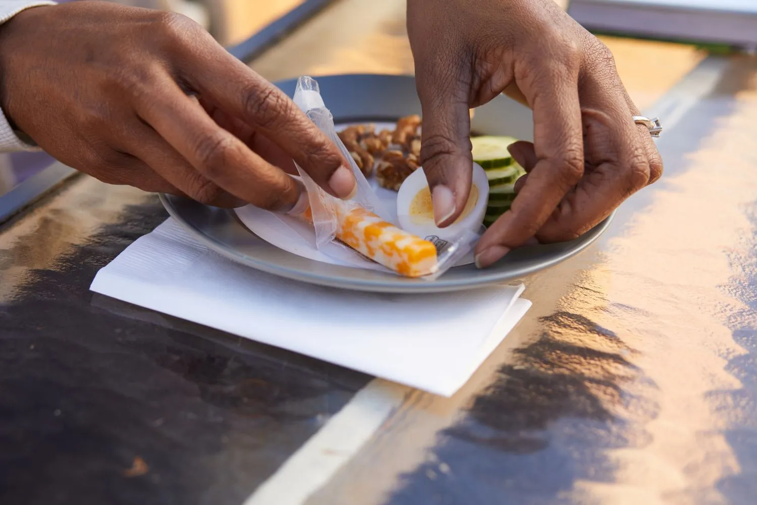 A snack plate featuring a cheese stick being prepared to eat.