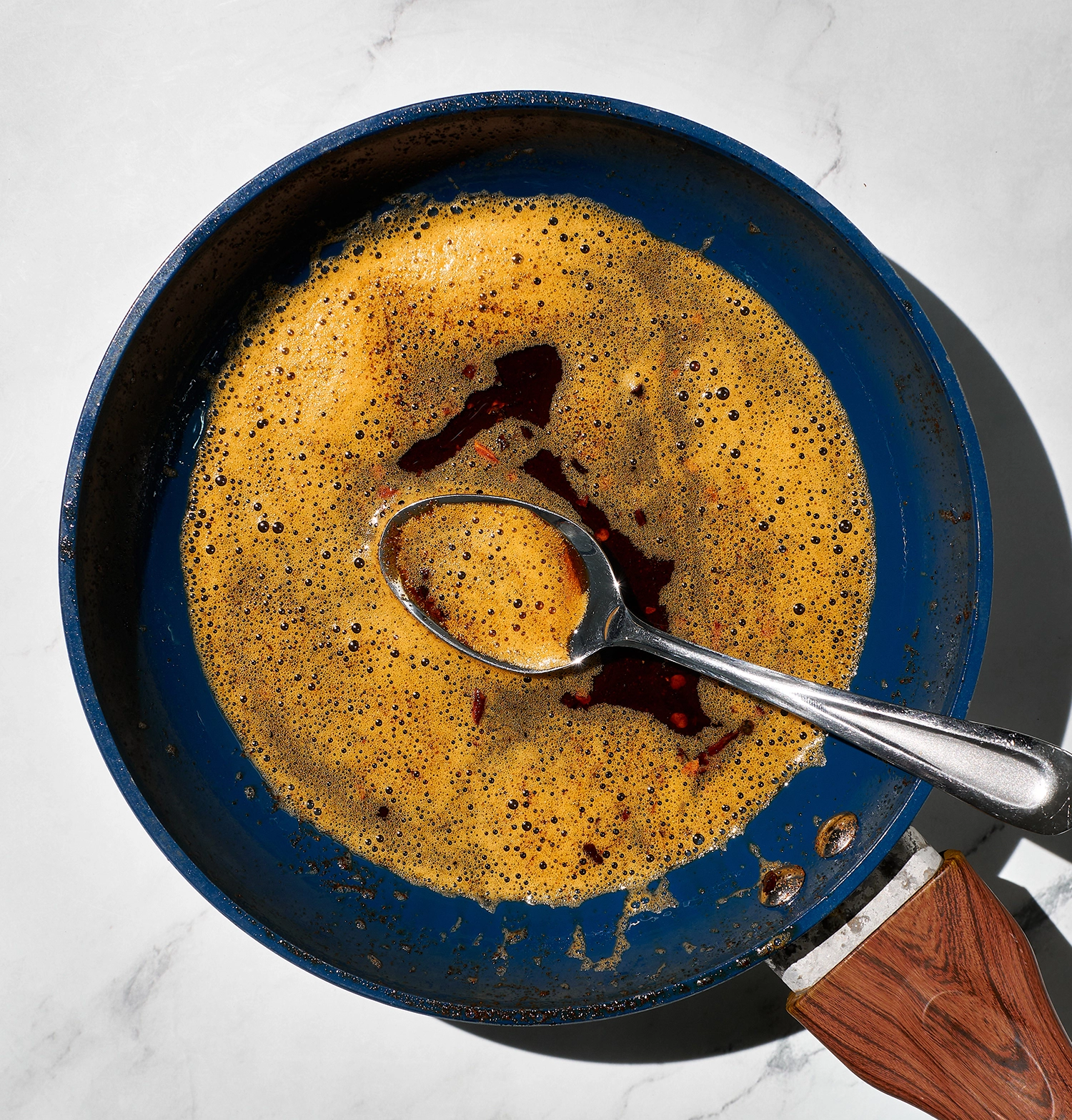 Melted butter combined in a small pan with olive oil, red pepper flakes, and paprika.