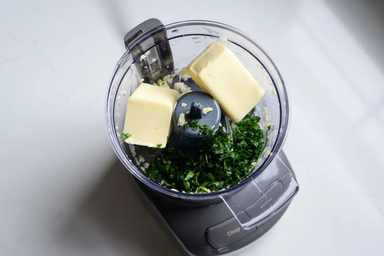 chicken-alfredo-garlic-2.jpg Butter, garlic, and parsley in a food processor.