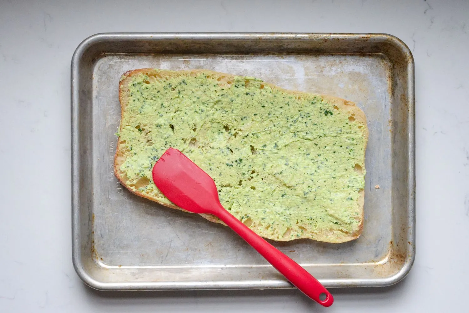 chicken-alfredo-garlic-3.jpg Butter, garlic, and parsley mixture evenly spread over a half slice of Ciabatta bread