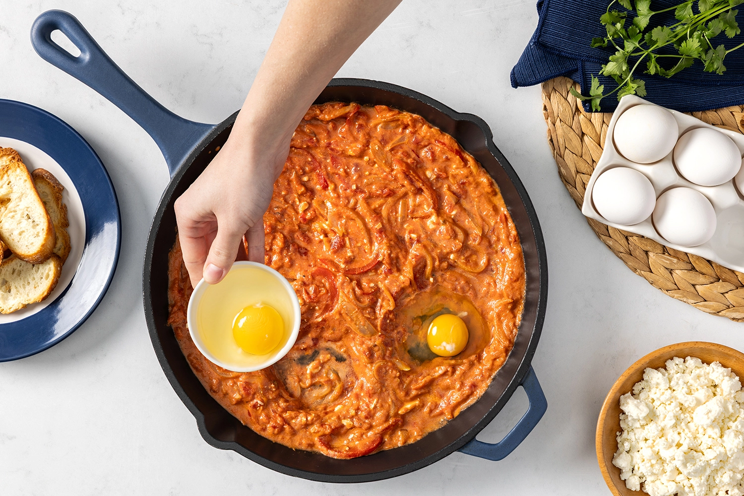 shakshuka sauce in a skillet with small wells to fill with cracked eggs.